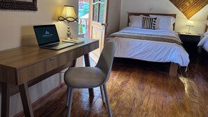 A bedroom with a wooden desk, laptop, chair, and a bed with a patterned blanket. - Andean Cottage w/ Garden & Workspace near Urubamba (Urubamba)