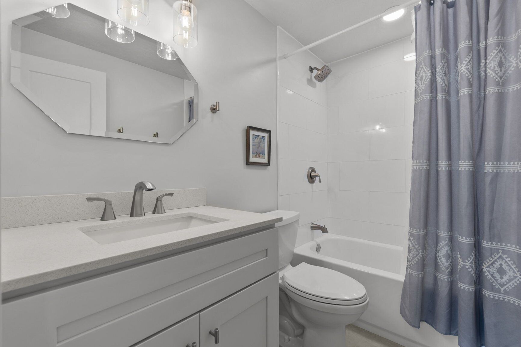 A modern bathroom with a double sink vanity, a toilet, and a bathtub.