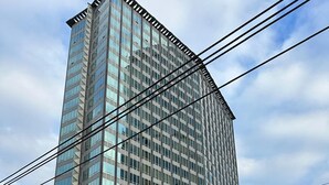 A tall, modern building with a glass facade, located at a street intersection. - Luxury Executive Downtown 1 bedroom Suite (Vancouver)