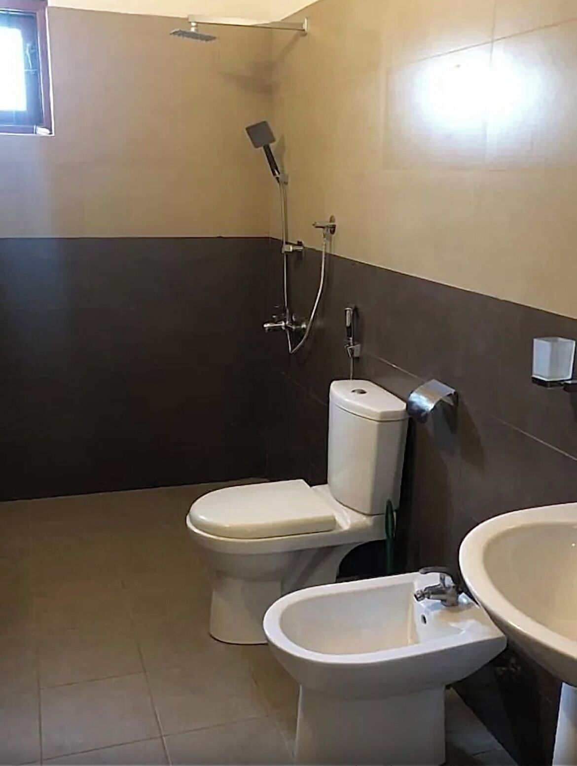 Un baño con inodoro, bidé y lavamanos.
