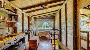 A wooden cabin interior with a bathtub, wooden shelves, and a window with curtains. - Fully Equipped Studios Near Armacao Beach and Beto Carrero Park - TRS (Penha)