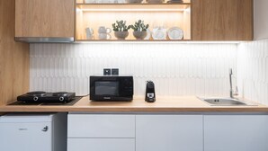 A modern kitchen with wooden cabinets, a microwave, a coffee maker, and a sink. - LIV - Comfortable Athens Studio S8-2A (Athens)