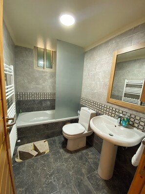 A bathroom with a bathtub, toilet, and sink. - Cedar House Jaj: Simple and Comfy Standard Room (Jaj)