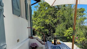 A patio area with a table and bench, surrounded by a white wall and a wooden fence. - House between Landes and Basque Country, Beach 3km away (Ondres)