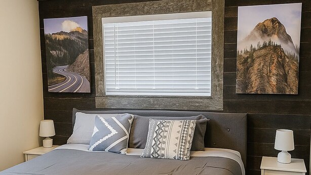 A bedroom with a bed, nightstands, a window with blinds, and wall art. - Applewood Charming Two Bedroom Big Fenced Yard (Fort Collins)
