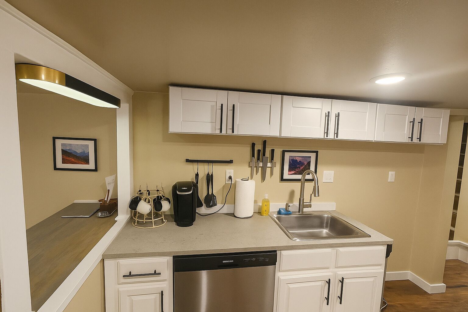 A modern kitchen with white cabinets, a stainless steel dishwasher, and a countertop with various kitchen items.