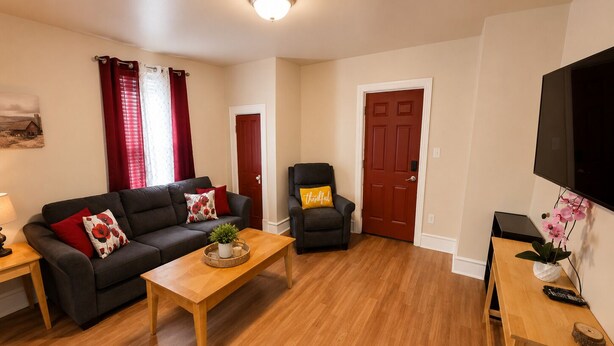 A living room with a sofa, armchair, coffee table, and a TV. - Farm Charm in Downtown Cheyenne (Cheyenne)