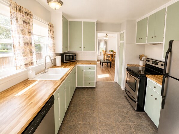 A kitchen with a dishwasher, microwave, stove, and refrigerator.
