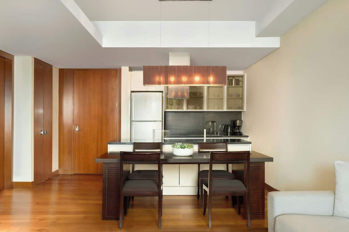 A modern kitchen with a central island, wooden cabinets, and a built-in oven.