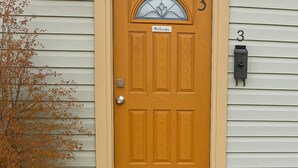 A wooden front door with a welcome sign, a mailbox, and a house number 3. - Cheyenne Frontier Homes #3 (Cheyenne)
