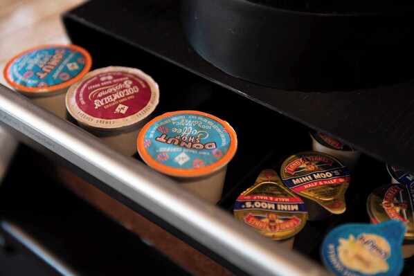 A drawer containing various food items including coffee creamer, chocolate spread, and other condiments.