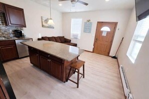 A spacious kitchen with a large island, wooden cabinets, and a ceiling fan. - Cheyenne Frontier Homes #2 (Cheyenne)