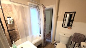 Une salle de bain équipée d’une douche, de toilettes, d’un lavabo et d’un miroir.