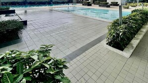 Un edificio moderno con varios balcones y una zona de piscina.