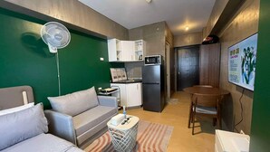 Un espacio habitable compacto con kitchenette, comedor y zona de estar.