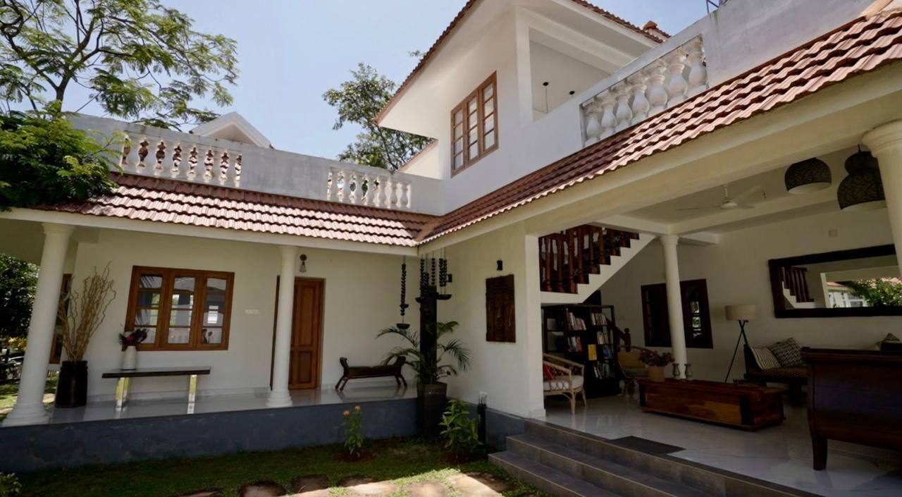 A spacious courtyard with a covered seating area, a staircase leading to an upper level, and a well-maintained garden.