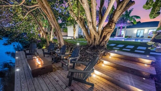A wooden deck with outdoor seating and a fire feature. - Waterfront Estate•7BR•Heated pool•Spa•BBQ•Basketball (Miami)