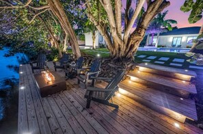 Une terrasse en bois avec des sièges extérieurs et un foyer.