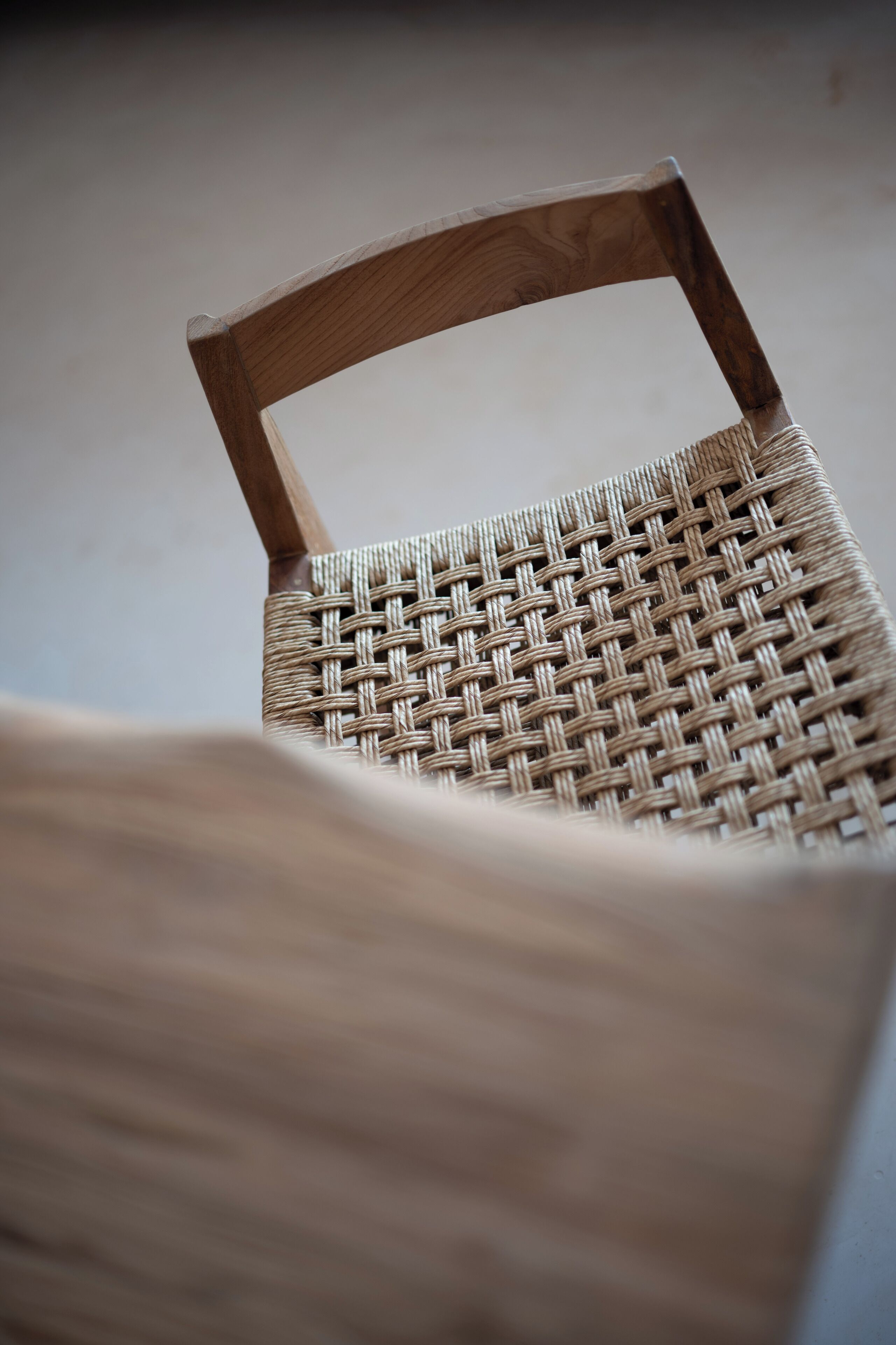 A close-up of a wicker chair with a wooden frame.