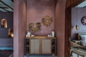 A room with a wooden console table, a sofa, and a bed.