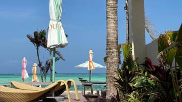 Sulla spiaggia, sabbia bianca, lettini da mare, ombrelloni