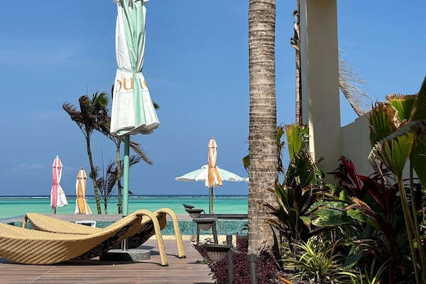 On the beach, white sand, sun-loungers, beach umbrellas