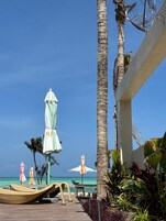 En la playa, arena blanca, sillas reclinables de playa, sombrillas