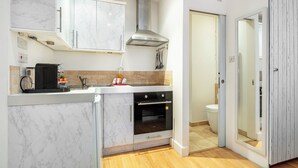 A compact kitchen with a built-in oven, a microwave, and a gas stove. - Charming Cozy Studio Apartment (London)
