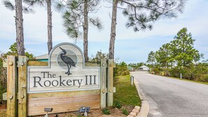 Un panneau en bois représentant un oiseau et portant l’inscription « The Rookery III », destiné à identifier une propriété.