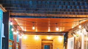 Eine Holzhütte mit Whirlpool, Holzwänden und Lichterkette.
