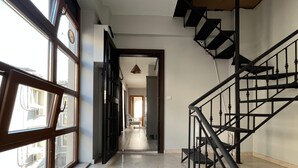 A corridor with a staircase, large windows, and a view into another room. - B-Cozy 1-bedroom apartment in enjoyable Istanbul with WiFi, AC (İstanbul)