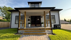 A two-story house with a front porch, a covered entryway, and a small front yard.
