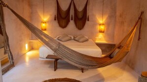 A hammock bed in a room with a bed, bedside tables, and wall-mounted lights. - APSARA 3 villas condominiums top pools in beautiful Tulum (Tulum)