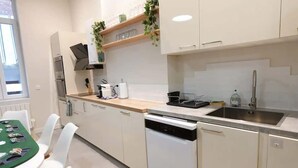 Una cocina moderna con armarios blancos, un lavavajillas, un fregadero y una encimera con un tostador.