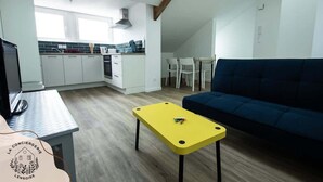 Un espacio habitable compacto con kitchenette, comedor y sofá.