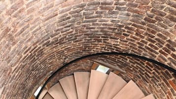Un escalier en colimaçon avec un mur en briques en arrière-plan.