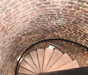 Eine Wendeltreppe vor einer Backsteinwand.