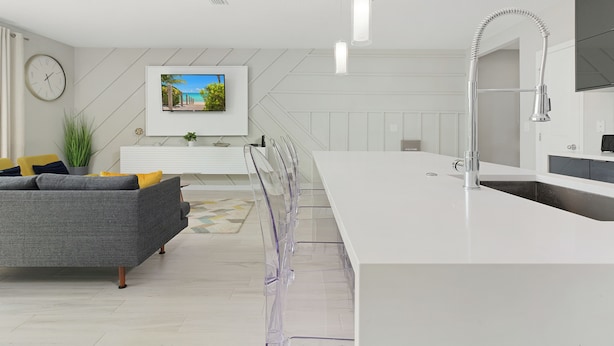 A modern kitchen with a white countertop, stainless steel faucet, and a built-in oven. - Luxury Townhome near attractions! (Kissimmee)