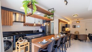 A modern kitchen with a central island, built-in appliances, and pendant lighting. - Modern duplex w/jacuzzi 240m beach JRR410 (Florianópolis)