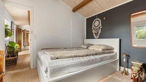 A bedroom with a bed, a dreamcatcher, a window, and a view of the outside. - Amazing home in Melby with sauna (Melby)