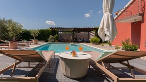 A pool area with lounge chairs, a table with drinks, and a pergola. - Family Dream Dalmatia - Split by Villas Guide (Košute)