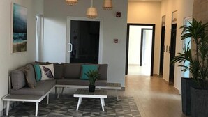 A modern living room with a sectional sofa, a coffee table, and a potted plant.