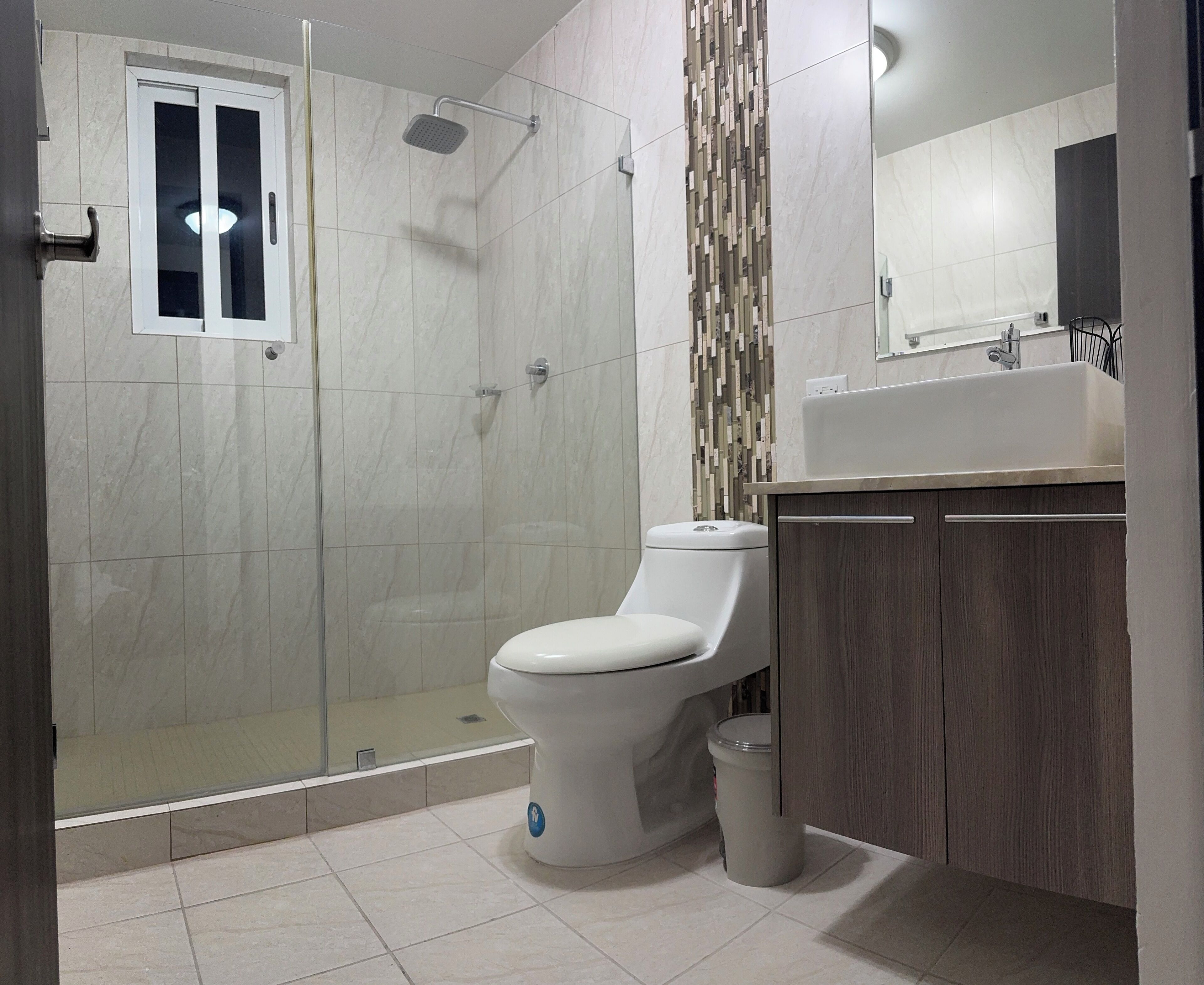 Ein modernes Badezimmer mit Dusche, Toilette und Waschbecken.
