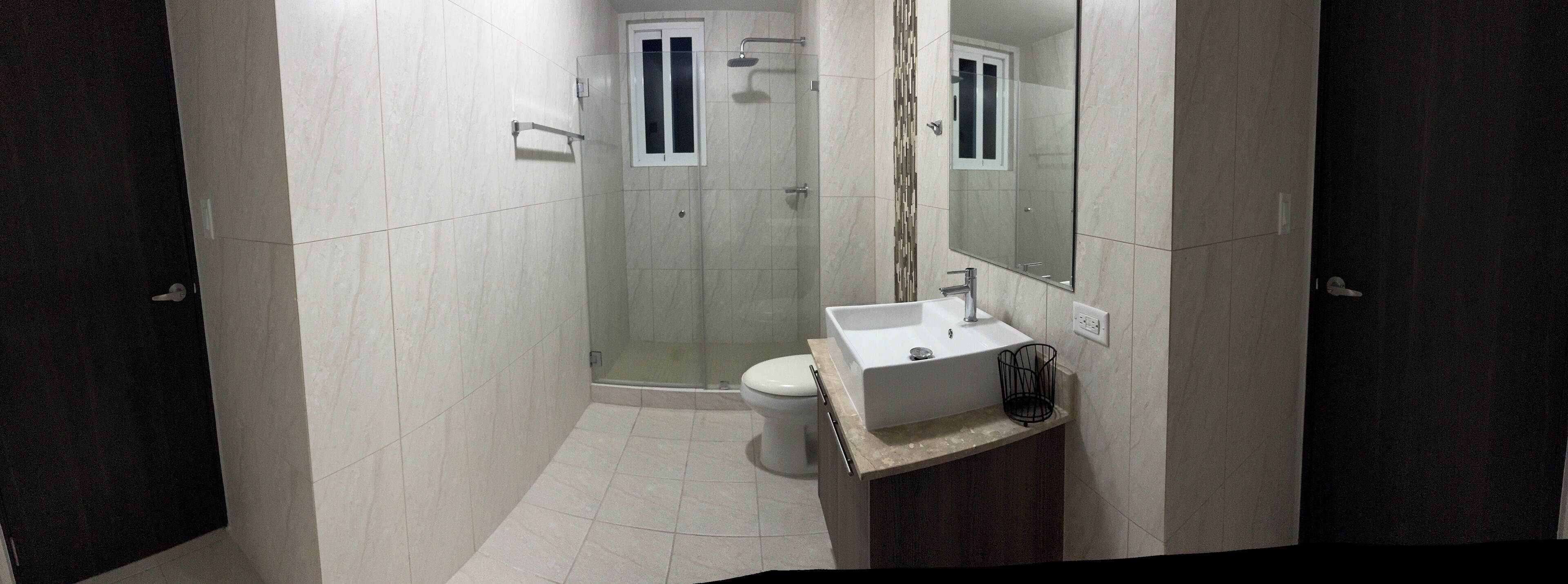 Une salle de bain moderne équipée d’une douche, de toilettes et d’un lavabo.