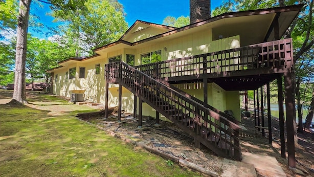 Una casa de dos pisos con una escalera de madera que da a un balcón.