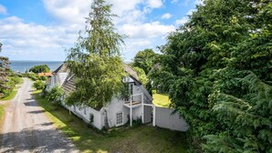 A coastal village with a narrow road, white houses, and lush greenery. - Amazing apartment in Asperup with sauna (Asperup)