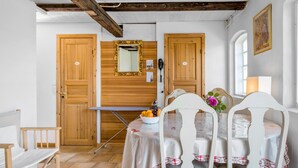 A dining area with a table set for two, a mirror above the table, wooden doors, and a window with a view. - Amazing apartment in Asperup with sauna (Asperup)