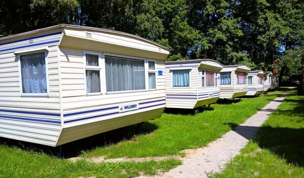 A row of mobile homes with a flat roof and a single window on each side, labeled "WILLERBY." - Dutch House in Lazy Near Lake Jamno (gmina Sianów)