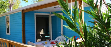 A blue mobile home with a dining area and a table set for two.