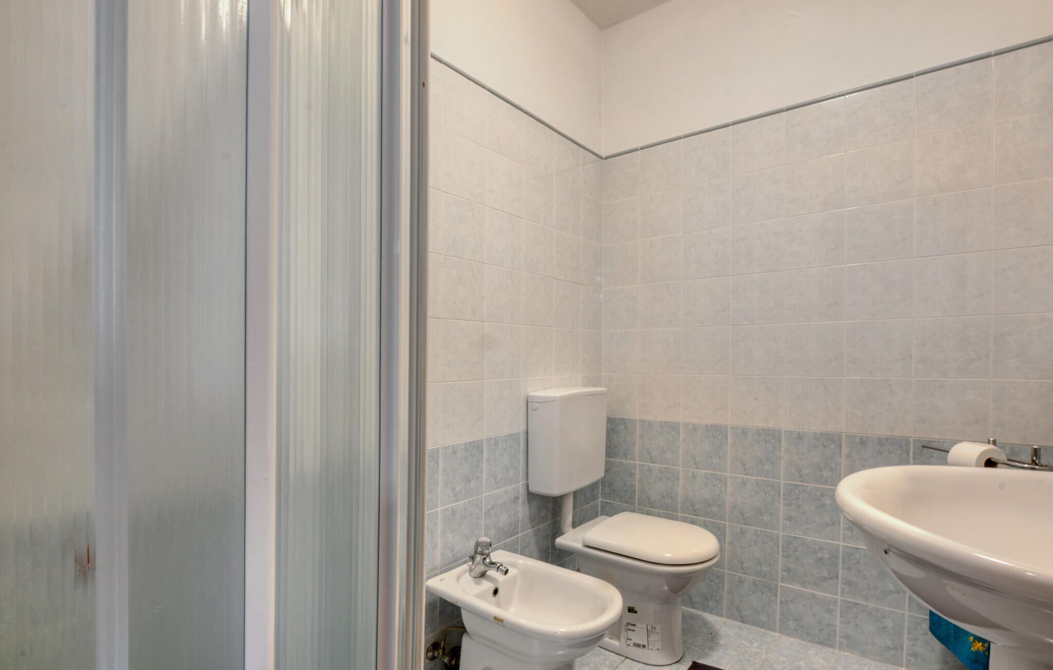 Et badeværelse med toilet, bidet og håndvask.